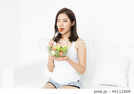 Young Asian woman is resting and eating a healthy salad blinking 49112806