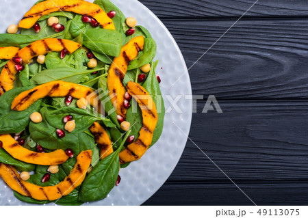 Autumn salad with pumpkin , spinach , pomegranate 49113075