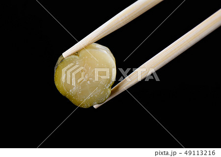 Chopsticks with a slice of pickled cucumber 49113216