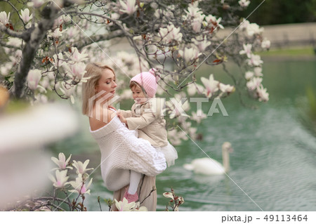 Happy family on a summer meadow. little girl child baby daughter hugging and kissing mother Happy family on a summer meadow. little girl child baby daughter hugging and kissing mother 49113464