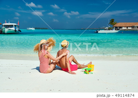 Woman applying sun screen lotion on man's back Woman applying sun screen lotion on man's back 49114874