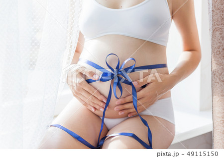 Pregnant woman with blue bow on belly.  49115150