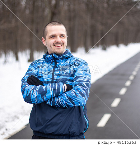 Sporty man runner looking on side and smiling Sporty man runner looking on side and smiling 49115263