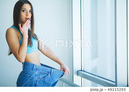 Diet. Beautiful Sporty Woman Showing How Much Weight She Lost Diet. Beautiful Sporty Woman Showing How Much Weight She Lost 49115293