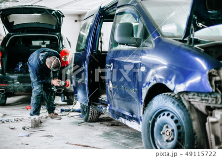 worker processes the surface of the car door worker processes the surface of the car door 49115722