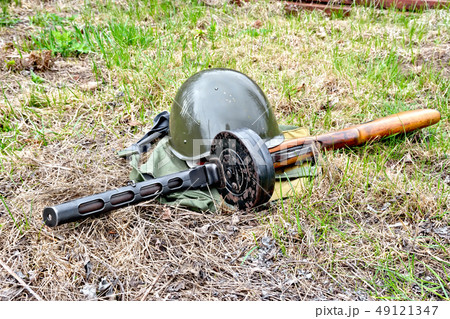 Helmet and submachine gun on ground Helmet and submachine gun on ground 49121347