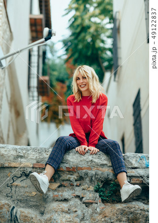 Smiling blonde girl with red shirt enjoying life Smiling blonde girl with red shirt enjoying life 49122837