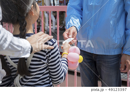 のりもの券を遊園地のスタッフに渡す子供手元 のりもの券を遊園地のスタッフに渡す子供手元 49123397
