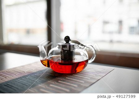 Glass teapot of invigorating fresh aromatic tea on Glass teapot of invigorating fresh aromatic tea on 49127599