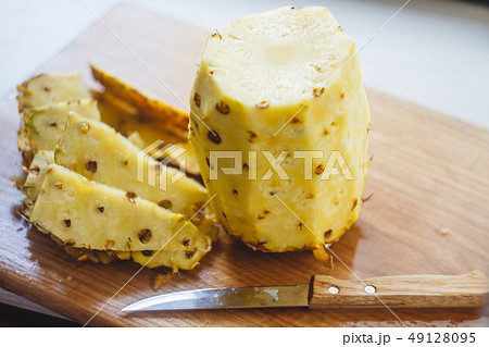 Pineapple shoe, slices, knife are on the board 49128095