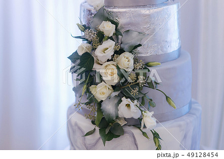 Beautiful wedding cake decorated with flowers. Silver and white color 49128454