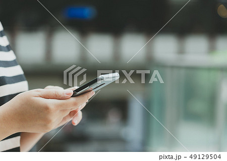 A beautiful Asian woman uses a smartphone in the 49129504