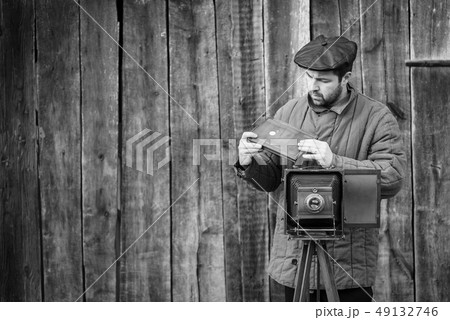 Photographer prepares for shooting on retro camera 49132746