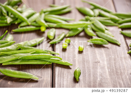 Green sugar snap pea on brown wood Green sugar snap pea on brown wood 49139287