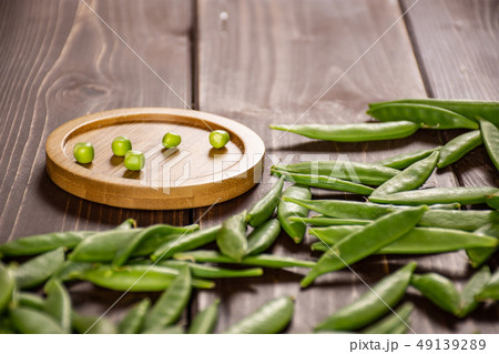 Green sugar snap pea on brown wood Green sugar snap pea on brown wood 49139289