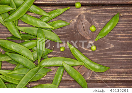 Green sugar snap pea on brown wood Green sugar snap pea on brown wood 49139291