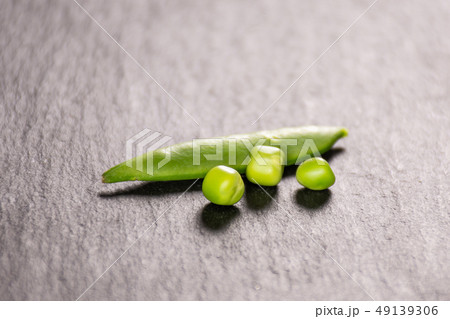Green sugar snap pea on grey stone Green sugar snap pea on grey stone 49139306