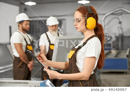 Engineers working with plasma laser cutter in factory. Engineers working with plasma laser cutter in factory. 49140067