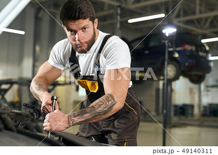 Handsome mechanic in uniform looking at camera. 49140311