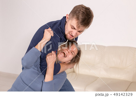 People, abuse and domestic violence concept - Portrait of man beating woman at home People, abuse and domestic violence concept - Portrait of man beating woman at home 49142329
