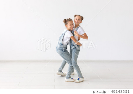 Family and love concept - two smiling twin sisters hugging over white background 49142531