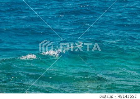 Wide shot of a beautiful clear turquoise sea ocean water surface with low ripples and subtle waves Wide shot of a beautiful clear turquoise sea ocean water surface with low ripples and subtle waves 49143653