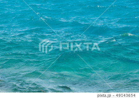 Wide shot of a beautiful clear turquoise sea ocean water surface with low ripples and subtle waves Wide shot of a beautiful clear turquoise sea ocean water surface with low ripples and subtle waves 49143654