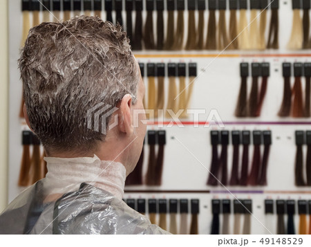 Man chooses paint to dye his hair. Man toning hair 49148529