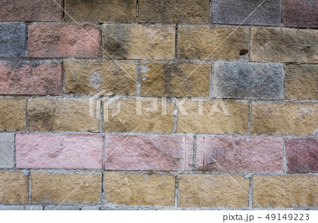 Yellow, red and grey brick shabby dirty wall. 49149223