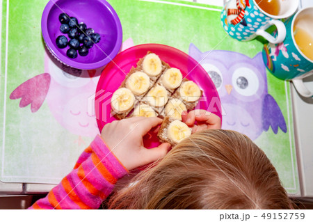 Little girl eating banana bread for breakfast 49152759