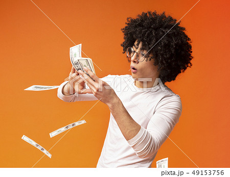 Happy young man throwing out money banknotes 49153756