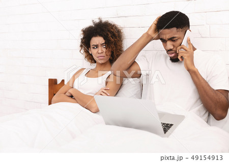 African-american guy working in bed and ignoring his wife 49154913