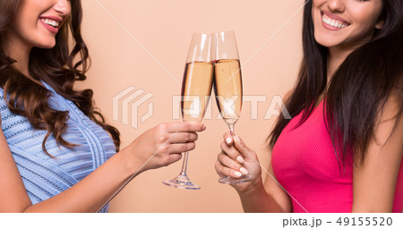 Beautiful girls in fashion dresses with champagne flutes 49155520