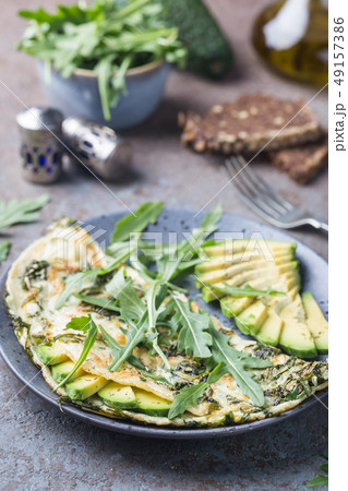 Omelette with avocado and arugula Omelette with avocado and arugula 49157386