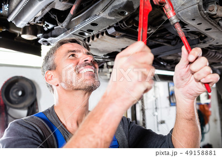 Smiling mature man repairing the car Smiling mature man repairing the car 49158881