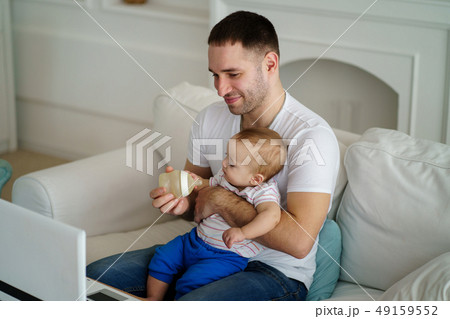 father feeding his little son from bottle 49159552