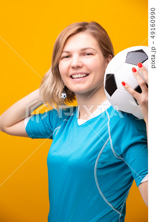 Photo of blonde with soccer ball on yellow background Photo of blonde with soccer ball on yellow background 49160990