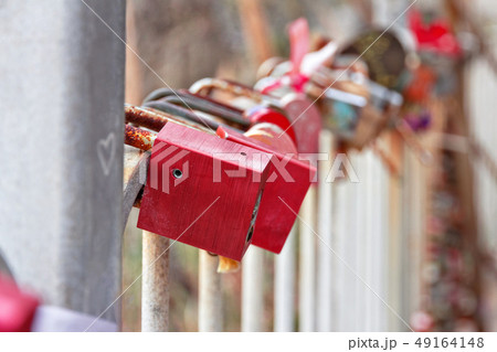 many old locks hang on iron fence 49164148