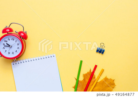 Alarm clock, empty notebook, pencils on yellow background. Alarm clock, empty notebook, pencils on yellow background. 49164877
