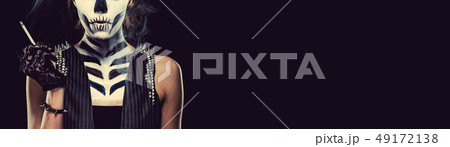 Woman with skeleton face art smoking over black Woman with skeleton face art smoking over black 49172138