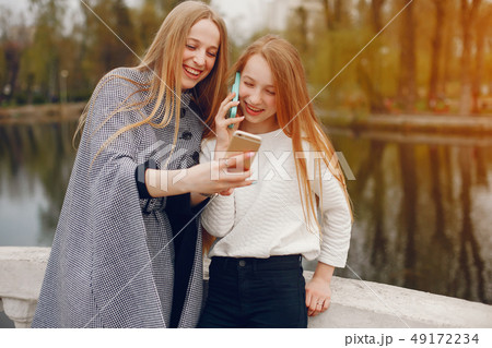 two pretty sisters in a park 49172234