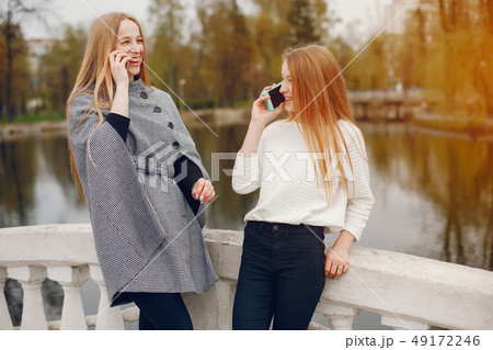 two pretty sisters in a park two pretty sisters in a park 49172246