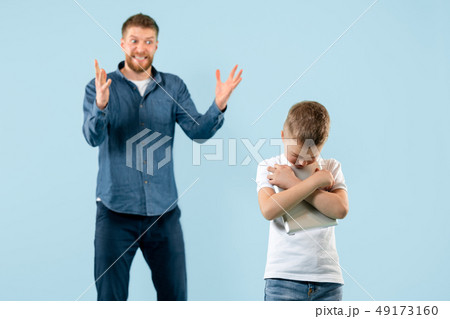 Angry father scolding his son in living room at home 49173160