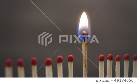 One burning match between spoiled ones on black 49174656