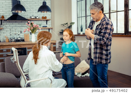 Serious mature man worrying about his daughters health Serious mature man worrying about his daughters health 49175402