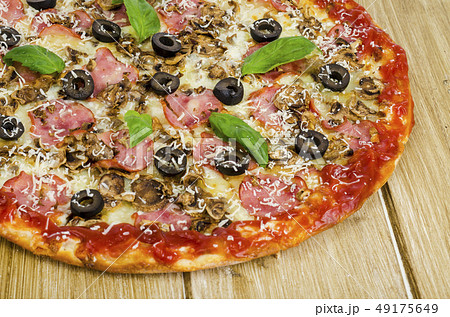 Pizza with ham, mushrooms and olives on wooden Pizza with ham, mushrooms and olives on wooden 49175649