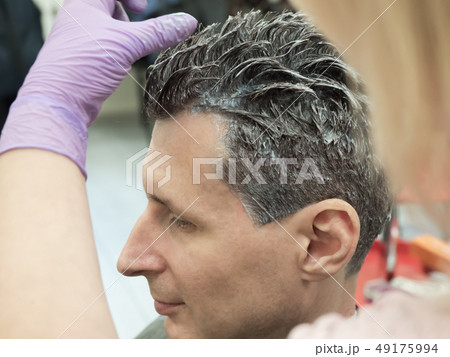 A man dyes his hair in the beauty salon. A man dyes his hair in the beauty salon. 49175994