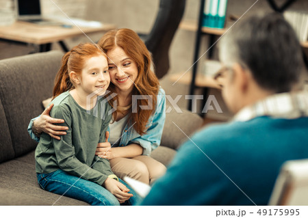 Delighted positive woman smiling to her daughter Delighted positive woman smiling to her daughter 49175995