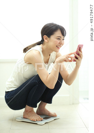 体重計にのる女性 49179477