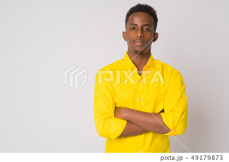 Young African businessman with yellow shirt crossing arms 49179873